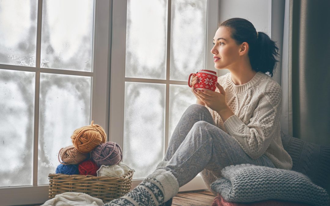 A chesterfield woman sitting by the window on a cold winter morning