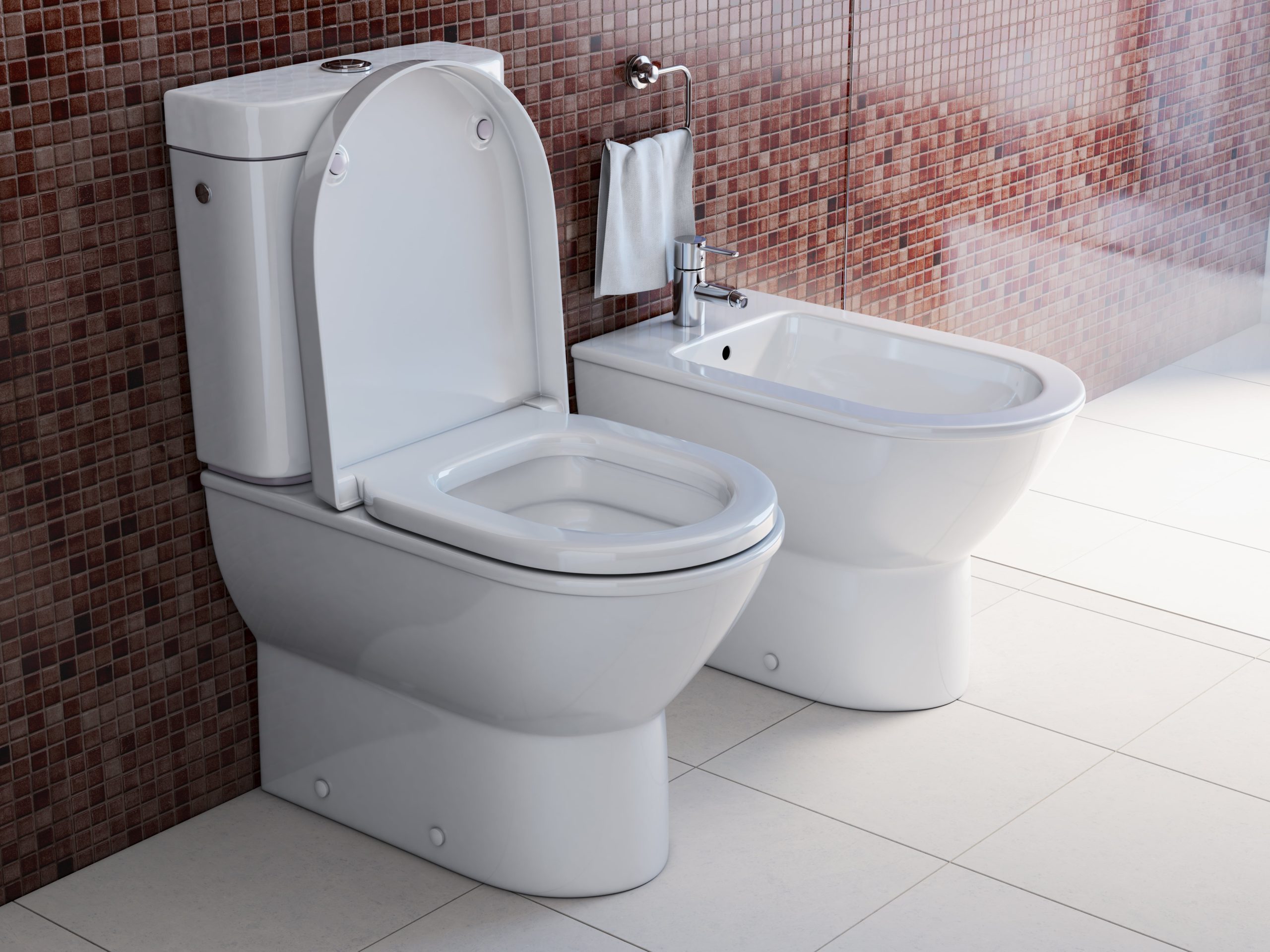 A toilet and a bidet next to each other in a bathroom.