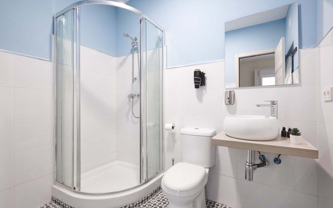 A clean renovated bathroom with a shower including a shower base and a shower pan.